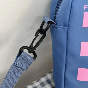 Detalle del gancho de plástico negro en un bolso de hombro azul de estilo japonés