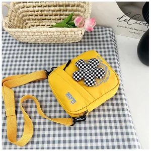 Elegante bolso bandolera de lona amarilla con detalle de flor a cuadros para uso casual diario