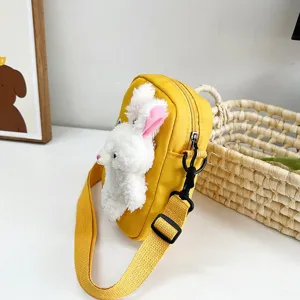 Vista detallada de un bolso bandolera amarillo de estilo japonés con un lindo conejo de peluche.
