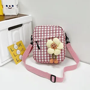 Detalle del mini bolso bandolera de cuadros rosas con una flor de felpa en 3D.