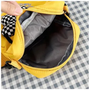 Detalle del forro interior gris y la cremallera del bolso bandolera amarillo para mujer