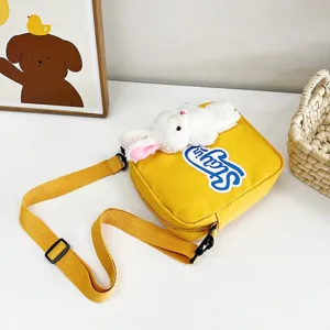 Vista detallada del conejito de peluche y el parche azul en un bolso bandolera amarillo