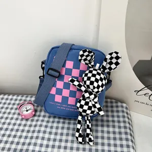 Detalle de un lindo bolso bandolera azul a cuadros con un accesorio de muñeco conejo
