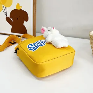 Detalle de bolso bandolera amarillo con decoración de conejo de peluche