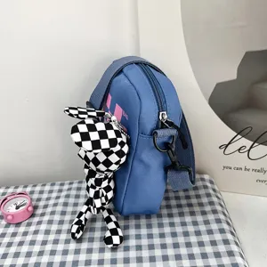 Primer plano del bolso bandolera azul de estilo japonés con llavero de conejo a cuadros