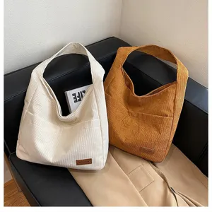 Close-up detail of stylish large capacity corduroy tote bags in white and brown colors