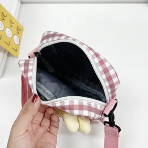 Vista detallada del forro interior gris de este mini bolso bandolera rosa a cuadros