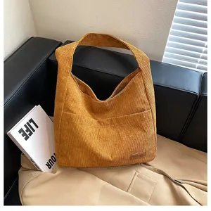 Close-up showing the soft corduroy texture and large capacity of the yellow tote bag.