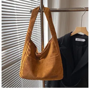 Close-up of brown corduroy tote bag showing textured fabric and brand label detail