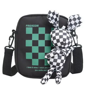 Elegante bolso bandolera negro con cuadros verdes y un lindo colgante de conejo