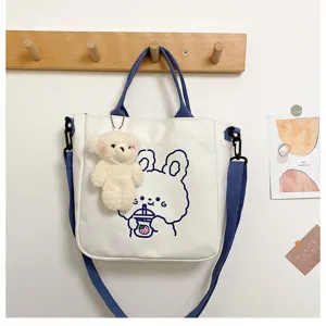 Detail einer süßen weißen Segeltuchtasche mit Hasenprint und Bärenschlüsselanhänger
