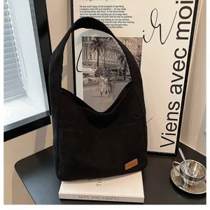 Detailed view of black corduroy tote bag styled in a minimalist aesthetic home setting
