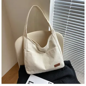 Stylish cream white corduroy shoulder tote bag for women shown in a cozy room setting