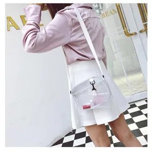 Vue détaillée d'un sac bandoulière en PVC transparent avec sangle blanche sur modèle