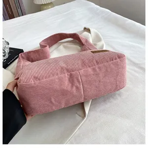 Detailed close-up view of a pink corduroy tote bag showing soft ribbed texture and strap
