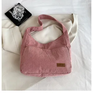 Detailed close-up view of a pink corduroy shoulder bag showing texture and logo patch