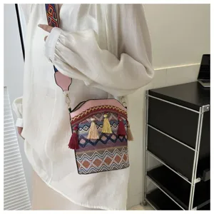 Detail einer ethnischen Eimertasche mit Quasten, die von einem Model getragen wird