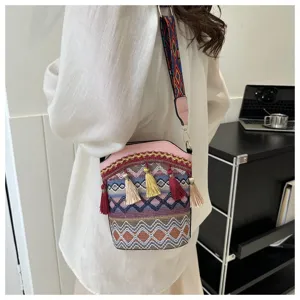 Detailansicht einer ethnischen Beuteltasche mit bunten Quasten und besticktem Gurt