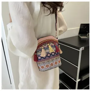 Detailansicht einer gewebten Eimertasche im ethnischen Stil mit bunten Quasten.