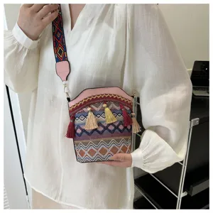 Detailaufnahme einer Vintage-Beuteltasche im Ethno-Stil mit bunten Quasten und Trageriemen.