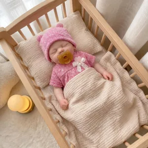 Vista detallada de una muñeca reborn de 13 pulgadas de silicona platino durmiendo en su cuna