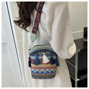 Ethnische Eimertasche mit buntem gewebtem Riemen und Quasten in der Detailansicht.