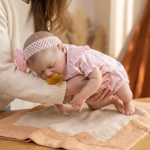 Detailansicht einer lebensechten 18-Zoll-Silikon-Reborn-Puppe in rosa Blumenoutfit.