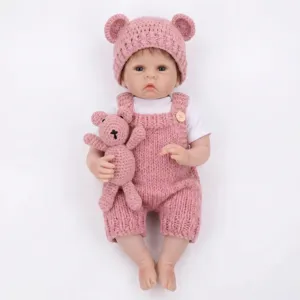 Detailed view of 22 inch reborn baby doll wearing a pink knitted romper and matching hat