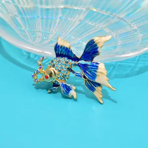 Detail view of an elegant blue enamel goldfish brooch featuring sparkling blue rhinestones