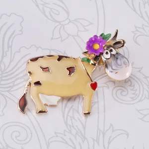 Detaillierte Makroansicht der niedlichen Emaille-Brosche Kuh mit lila Blume und Herz