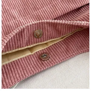 Detailed close-up showing the secure magnetic snap closure of a pink corduroy tote bag