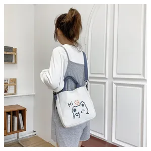 Süße weiße Canvas-Schultertasche mit Tiermotiv, getragen von einer jungen Frau.