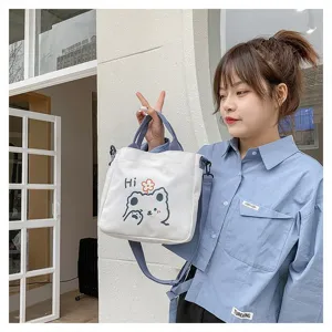 Asiatisches Model hält eine süße weiße Canvas-Tragetasche mit einem Cartoon-Bären-Druck
