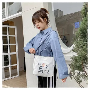 Model trägt eine weiße Segeltuchtasche im japanischen Stil mit süßem Bären-Print.