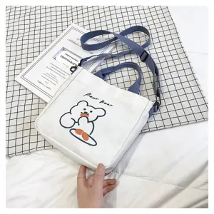 Detailansicht der weißen Canvas-Tasche mit Bärenprint und blauem Trageriemen