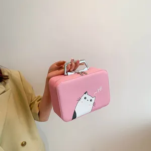 Détail d'une trousse de maquillage chat rose avec poignée argentée et texture cuir.