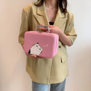Gros plan d'une trousse à maquillage rose tendance avec imprimé chat tenue par un mannequin