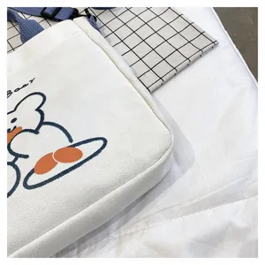 Nahaufnahme des niedlichen Bärenmusters und Materialdetails der weißen Segeltuchtasche