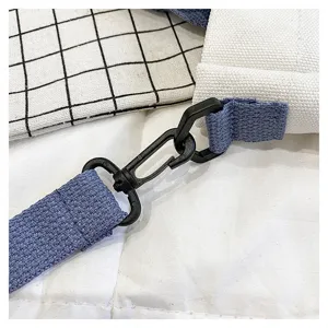 Detailaufnahme des schwarzen Karabinerhakens und des blauen Canvas-Gurts der Tasche.