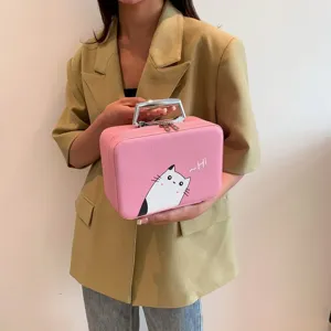 Vue détaillée de la trousse de maquillage chat rose tenue par un mannequin