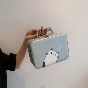 Vue détaillée d'une trousse à maquillage argentée avec chat mignon et poignée solide.