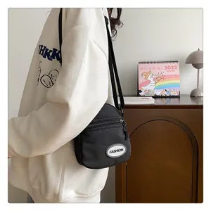 Vista detallada de un bolso bandolera de nailon negro minimalista en una escena de estilo de vida
