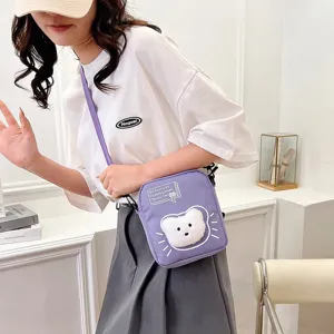 Detalle de bolso bandolera moderno en nylon morado con parche de gato de peluche