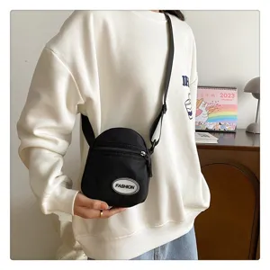 Vista lifestyle de un bolso bandolera pequeño de nailon negro ligero y casual