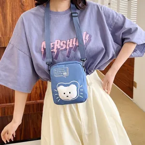 Bolso bandolera de nailon azul con detalle de oso de peluche sobre camiseta lila