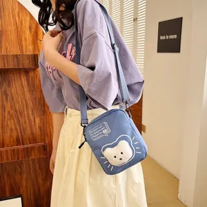 Detalle de un bolso bandolera de nailon azul con un lindo parche de gato en una modelo