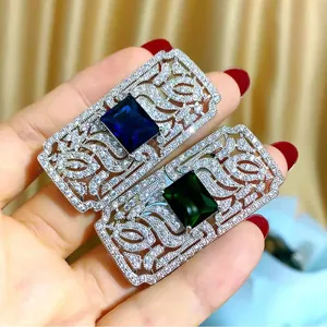 Dettaglio di spille rettangolari in lega di zinco con pietre preziose blu e verdi.