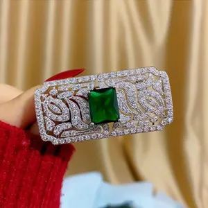 Dettaglio macro di spilla vintage con pietra verde smeraldo e pavé di cristalli