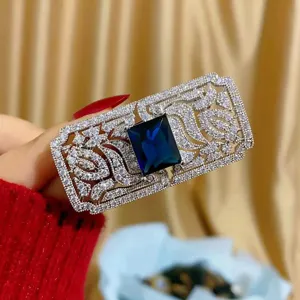 Dettaglio macro di una lussuosa spilla rettangolare con cristallo blu e argento