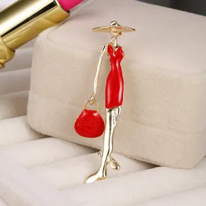 Detail of elegant lady brooch with vibrant red enamel dress, golden jewelry finish.